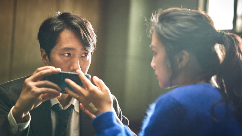 Det. Jang Hae-jun looks at Song Seo-rae in "Decision to Leave" (2022)