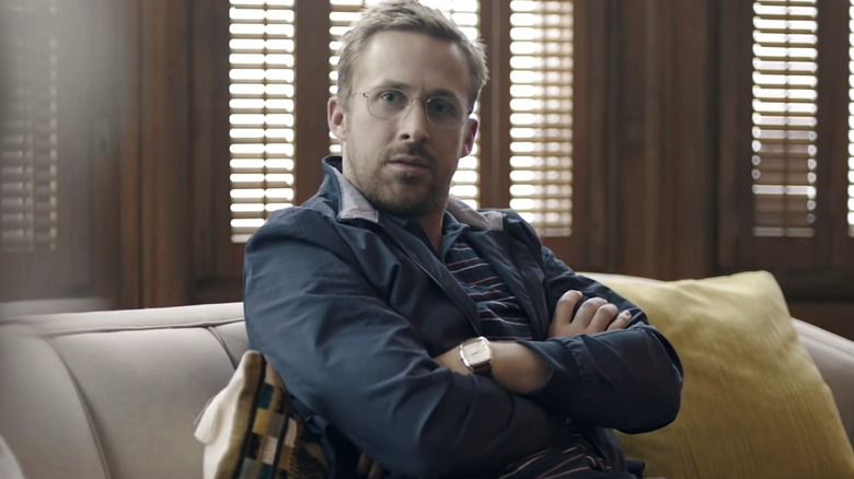 Ryan Gosling sits on a couch