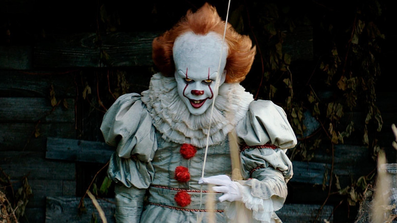 Pennywise smiling with a balloon in "It" (2017)
