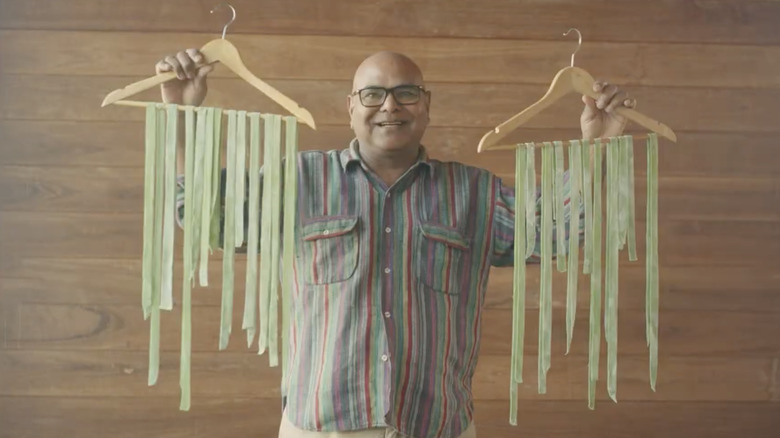 Vacationer holds pasta on hangers