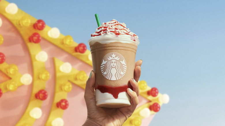 A hand holding the Starbucks Funnel Cake Frappuccino