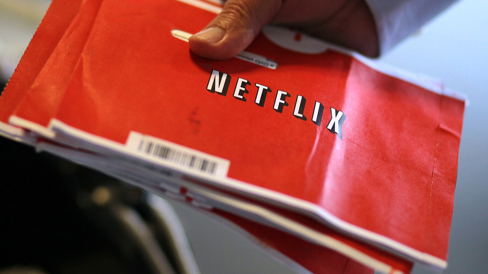 Man holding Netflix DVD envelopes