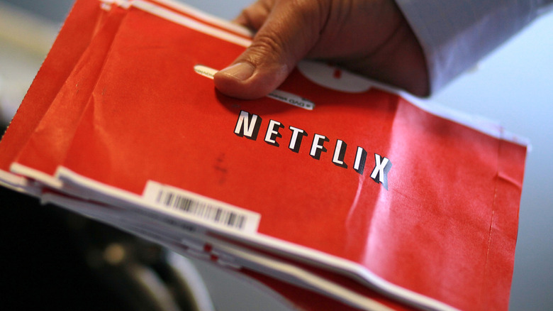 Man holding Netflix DVD envelopes