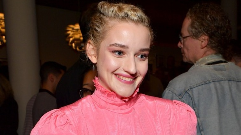 Julia Garner smiing in pink dress