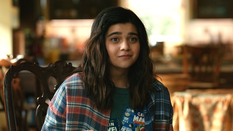 Kamala Khan smiling in a flannel shirt at a kitchen table in The Marvels (2023)