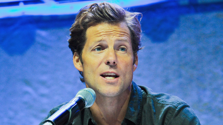 Jamie Bamber speaks into a microphone