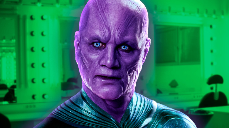 Abin Sur from Green Lantern with purple skin and light blue eyes against a green make-up room background