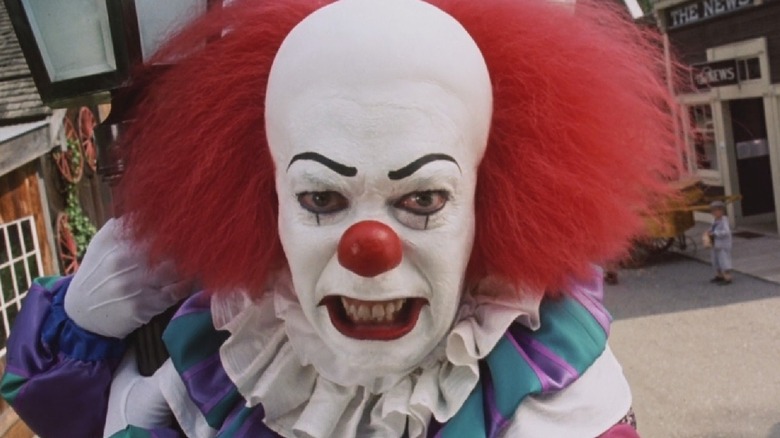 Tim Curry as Pennywise snarling at a street camera