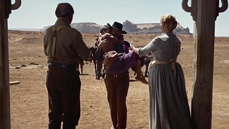 John Wayne carries young girl