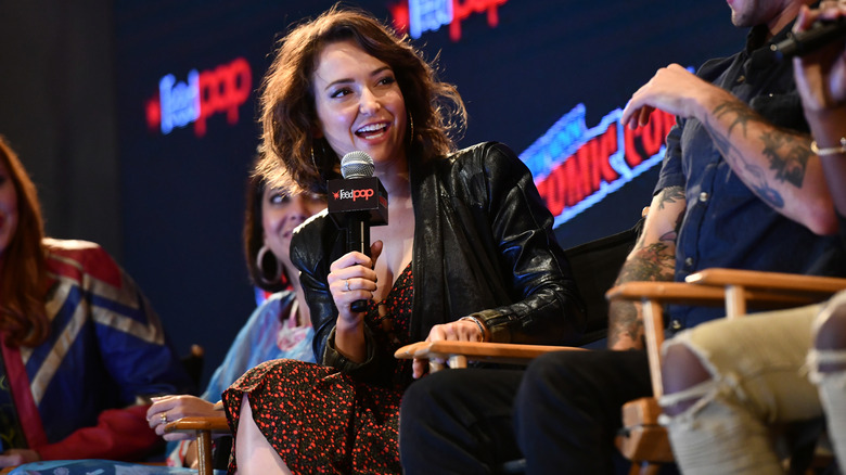 Milana Vayntrub държи микрофон и говорене