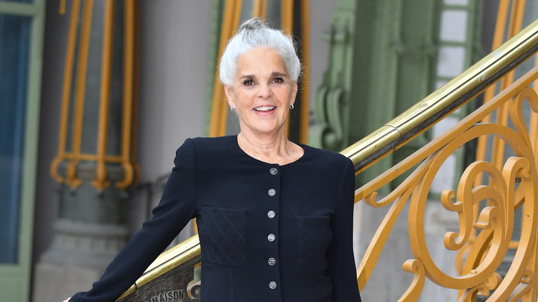 Ali MacGraw leans on a staircase