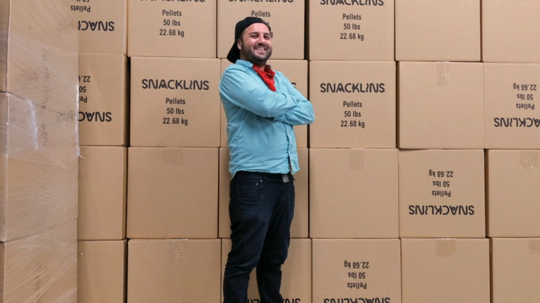 Sam standing in front of Snacklins boxes