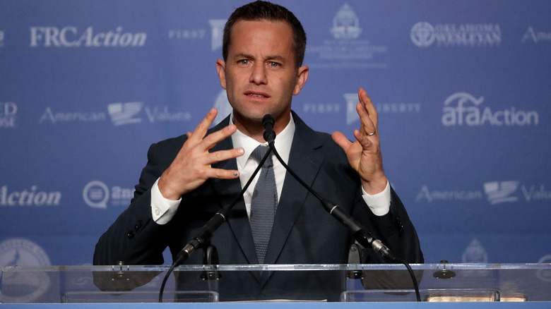 Kirk Cameron speaking at a podium 