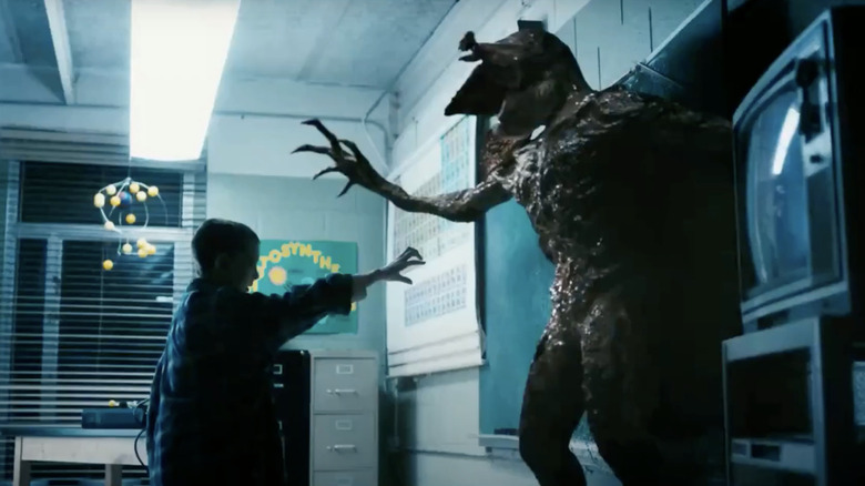 Eleven pushes Demogorgon against wall 