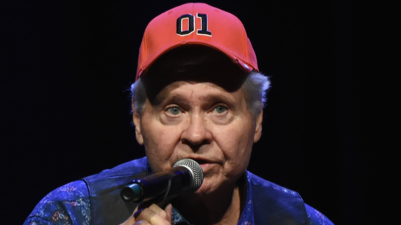 Ben Jones, in General Lee hat, speaks into a microphone
