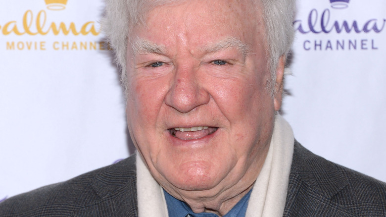 James Best, in coat and scarf, smiles broadly