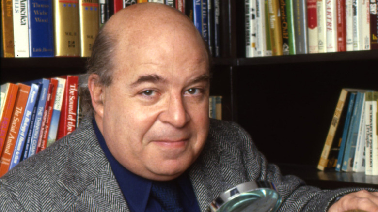 Sorrell Booke uses a magnifying glass in a library