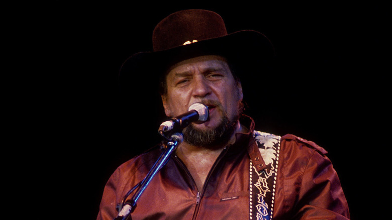 Waylon Jennings plays guitar and sings