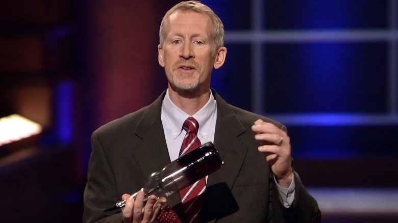 Eric Corti holding wine bottle upside down 