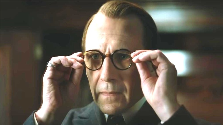 Ralph Fiennes putting on glasses