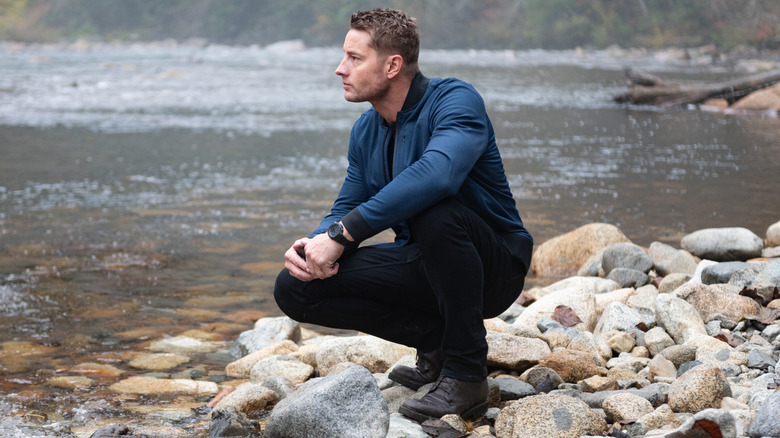 Colter Shaw kneels by a river in 