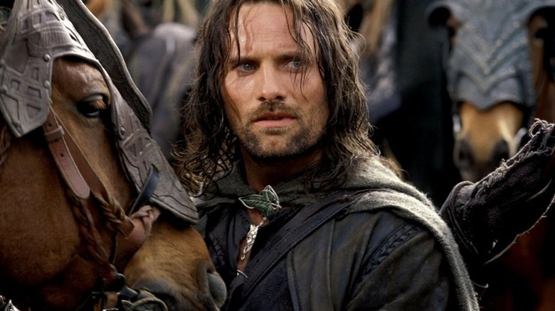 Aragorn looking concerned standing next to his horse