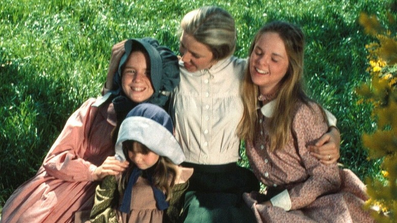 Caroline, Mary, Carrie and Laura Ingalls laugh in the grass in "Little House on the Prairie"
