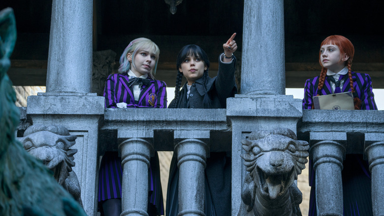 Enid, Wednesday, and Agnes standing on a Nevermore balcony in "Wednesday."