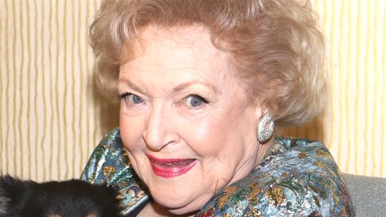 Betty White smiling with a dog