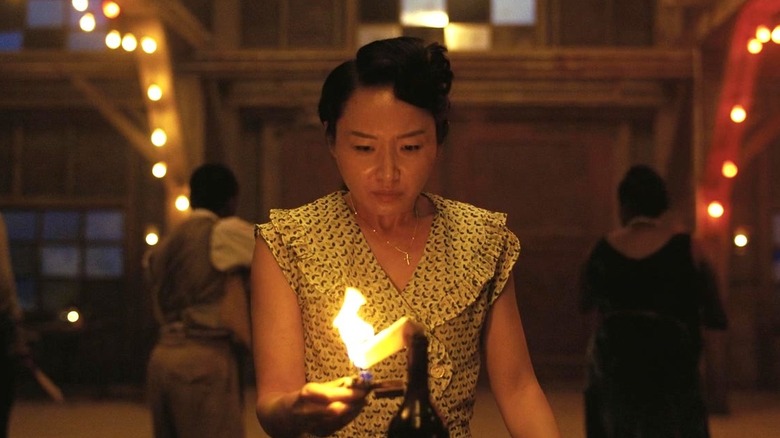 Grace Chow lighting a fire in "Sinners" (2025)