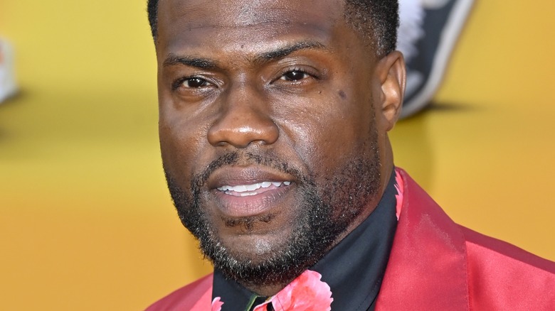 Kevin Hart smiling in red suit