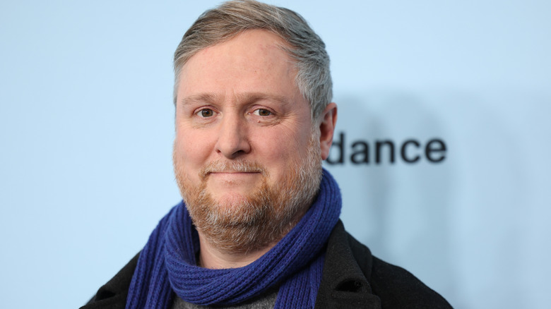 British actor Tim Key smiling for a photo in front of a white wall at the Sundance Film Festival