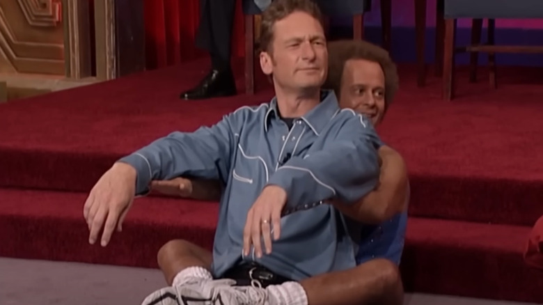 Richard Simmons with legs wrapped around Ryan Stiles