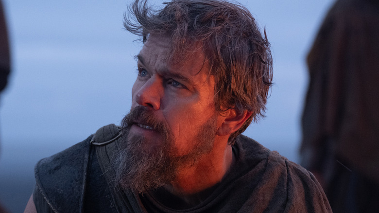 Odysseus looks up with a gray sky behind him in 
