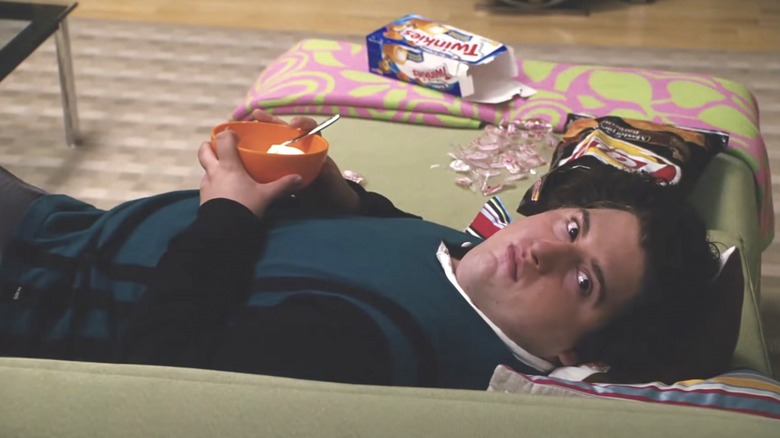 Ben laying on the couch with junk food