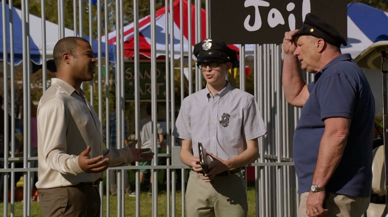 Derrick and Jay Pritchett argue while a teenage boy looks on