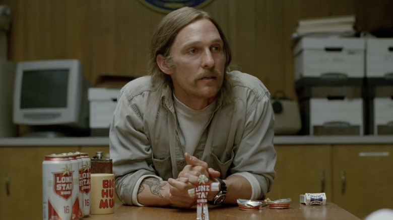 Rust Cohle sitting next to beer cans