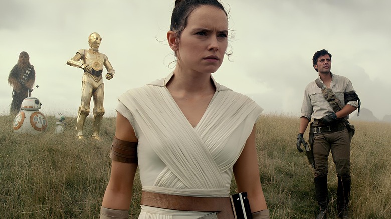 Chewbacca, BB8, C3PO, Rey Skywalker, and Poe look on