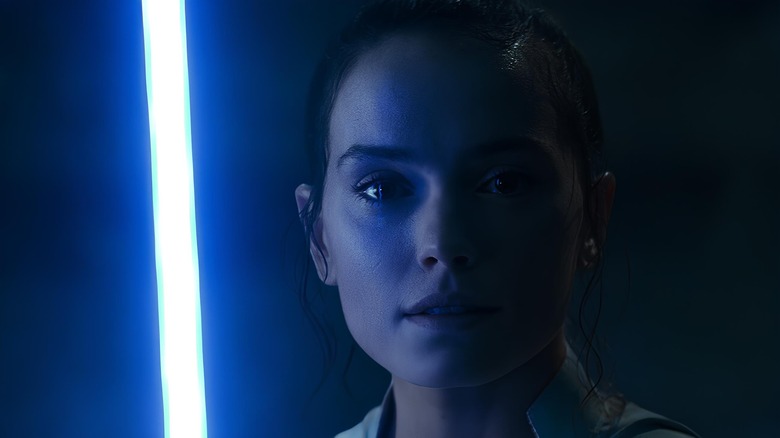 Rey Skywalker holding lightsaber