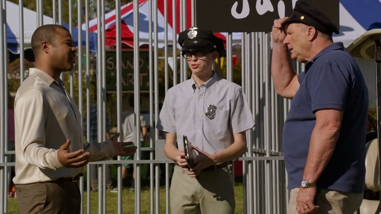 Derrick and Jay Pritchett argue while a teenage boy looks on
