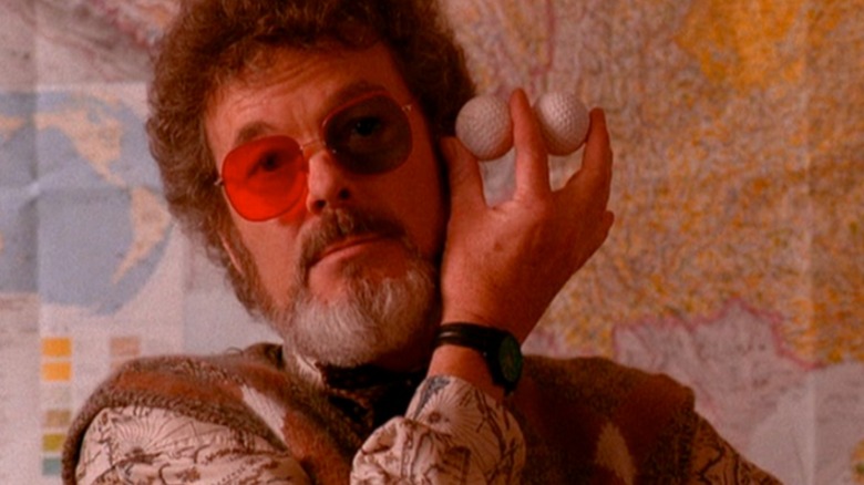 Dr. Jacoby holds two golf balls by his face