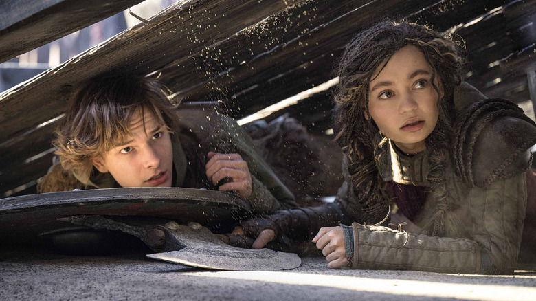 Hiccup and Astrid hiding under platform in "How To Train Your Dragon" (2025)