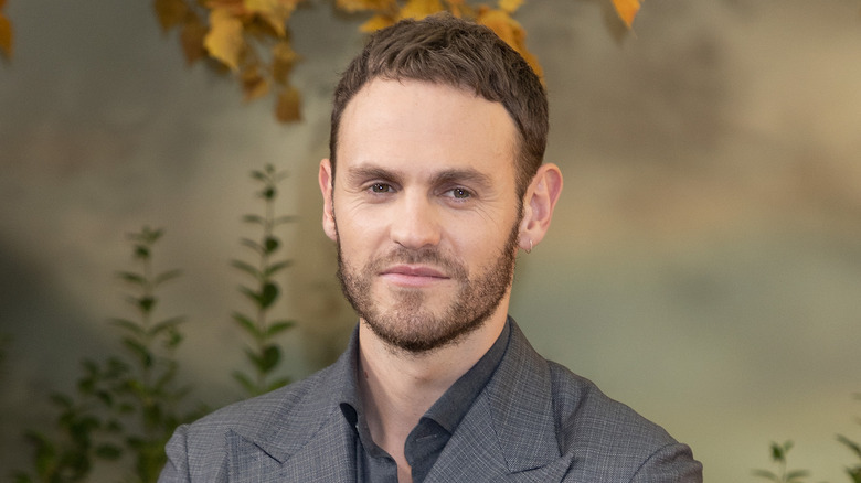 Charlie Vickers smiling in a grey suit