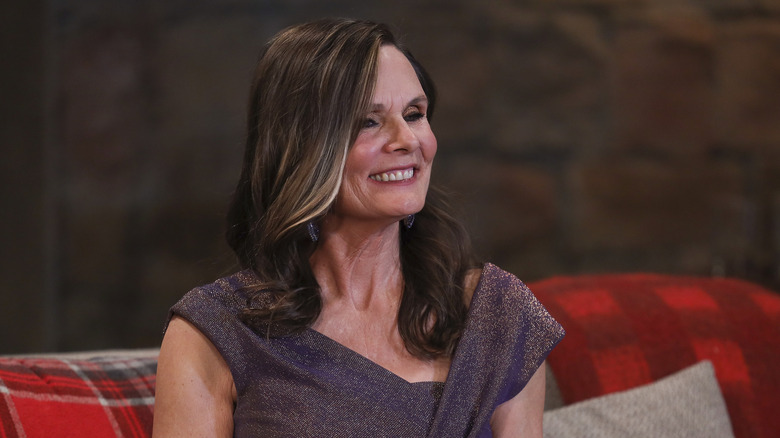 Lucy Coe smiling on a couch