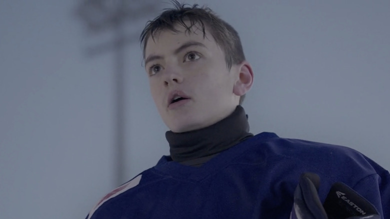 Oleg wearing blue hockey uniform