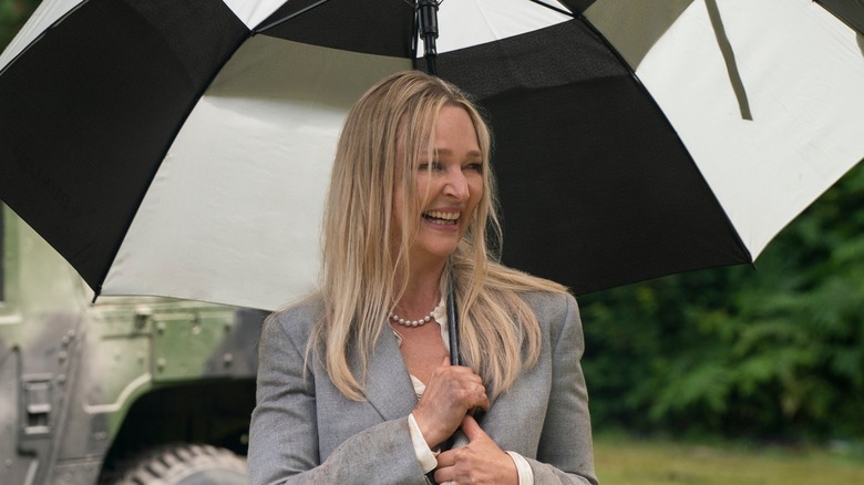 President Travers holding an umbrella and laughing 