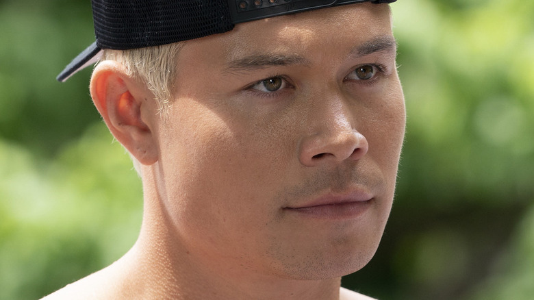 Colton Tran as Reece, looking angry and wearing a backwards hat