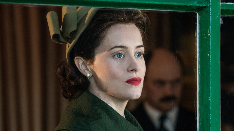 Claire Foy as Queen Elizabeth II looking out the window on The Crown