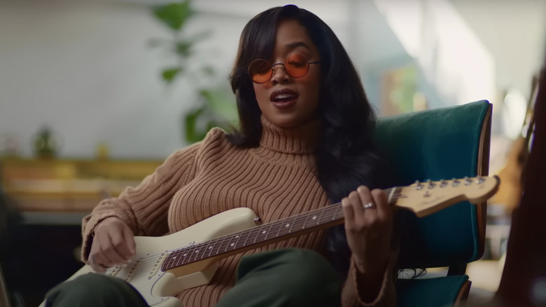 H.E.R. playing guitar