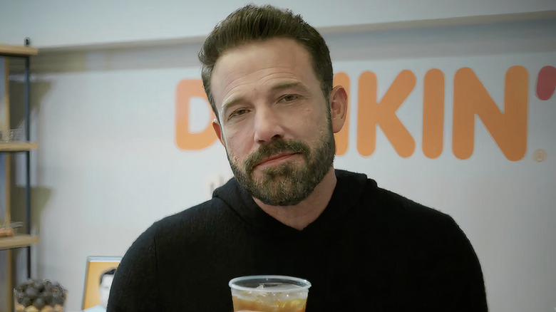 Ben Affleck wearing black sweater holding ice coffee